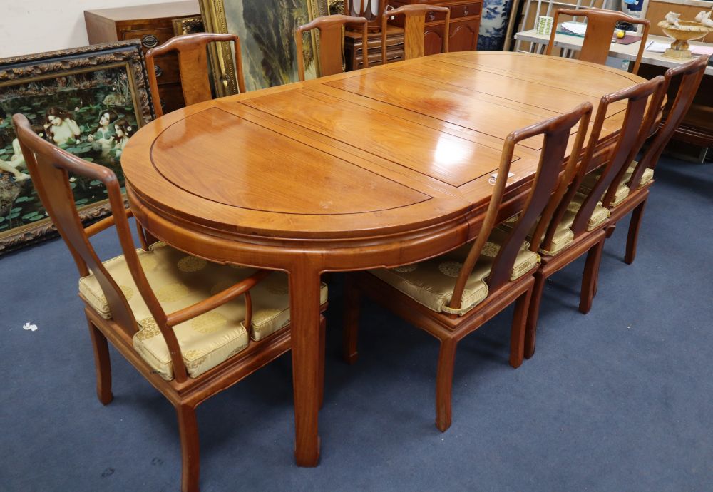 A Chinese hardwood dining table, 234cm extended (three spare leaves), width 112cm, height 76cm and eight chairs